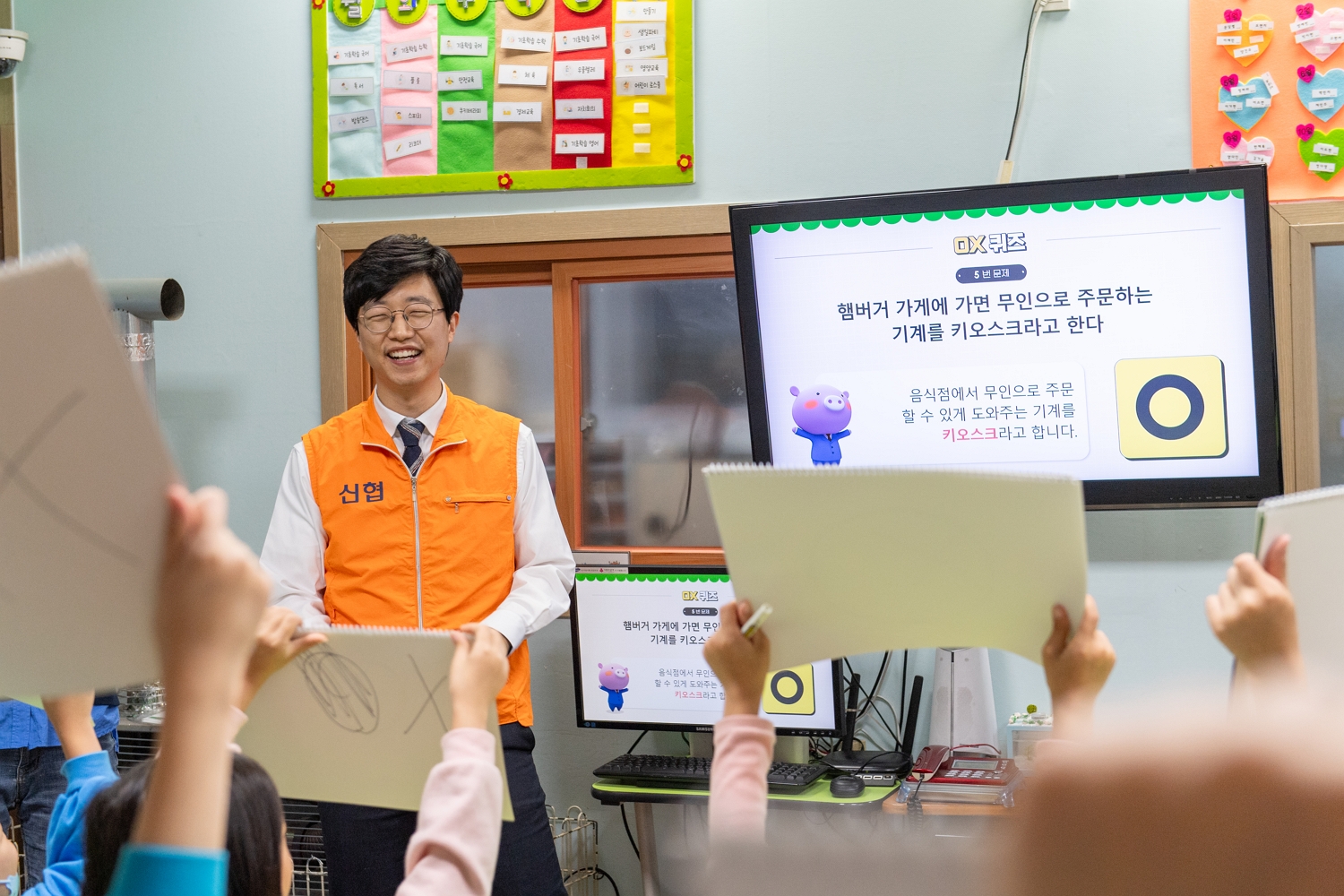   사진 1. 신협 임직원 멘토가 아동 멘티에게 경제 골든벨을 진행하고 있다.